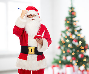 Image showing man in costume of santa claus with notepad