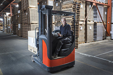 Image showing Fork lift operator preparing products for shipment