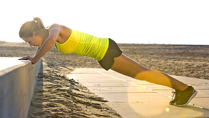 Image showing Woman doing Press ups on a beach