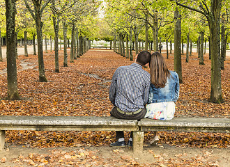 Image showing Young Couple Sitting on a Bench in a Park in Autumn