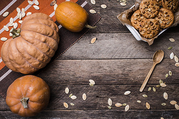 Image showing Rustic style pumpkins and cookies with nuts on wood