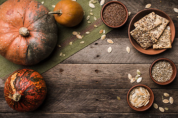 Image showing Rustic style pumpkins with cookies and seeds on wood. 