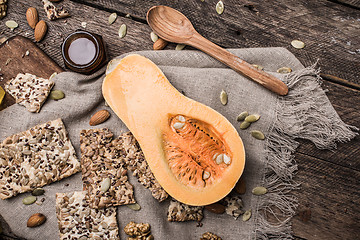 Image showing Cut Pumpkin, honey, and cookies with seeds on wood