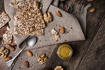 Image showing Nuts, Cookies with seeds and honey on wooden table