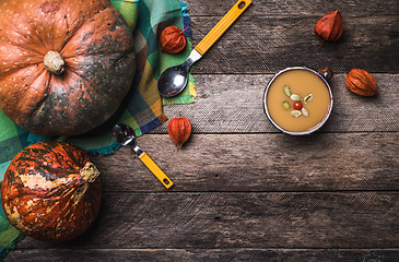 Image showing Rustic style pumpkins and soup with seeds and ground cherry on w
