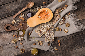 Image showing Cut Pumpkin with  honey cookies and seeds on wooden table