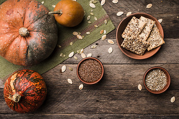 Image showing Rustic style autumn pumpkins with cookies and seeds on wood