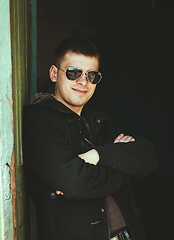 Image showing Young Handsome Man Staying Near Old Wooden House In Autumn Or Sp