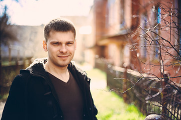 Image showing Young Handsome Man Staying Near Old Wooden House In Autumn Or Sp