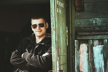 Image showing Young Handsome Man Staying Near Old Wooden House In Autumn Or Sp