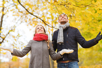 Image showing smiling couple looking up in autumn park