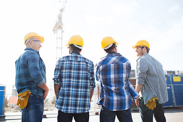 Image showing group of smiling builders in hardhats outdoors