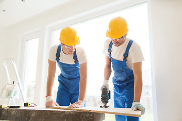 Image showing group of builders with tools indoors