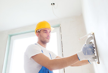 Image showing builder with grinding tool indoors