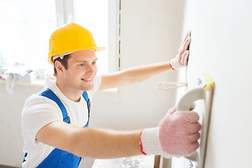 Image showing smiling builder with grinding tool indoors