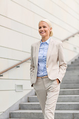 Image showing young smiling businesswoman walking down stairs