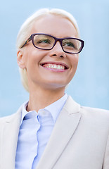 Image showing young smiling businesswoman over office building