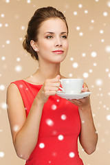 Image showing smiling woman in red dress with cup of coffee