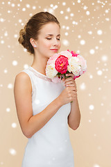 Image showing smiling woman in white dress with bunch of flowers