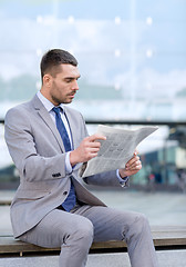 Image showing young serious businessman newspaper outdoors