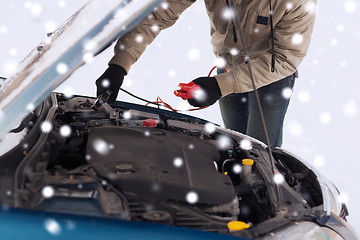 Image showing closeup of man under bonnet with starter cables