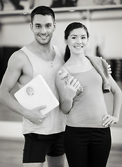 Image showing two smiling people with scale in the gym