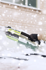 Image showing closeup of man cleaning snow from car