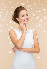Image showing smiling woman in white dress with diamond ring