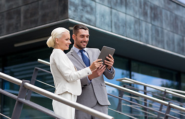 Image showing smiling businessmen with tablet pc outdoors