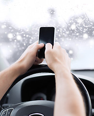 Image showing close up of man using smartphone while driving car