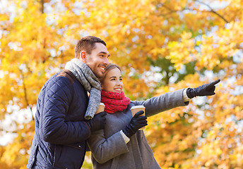 Image showing smiling couple with coffee cups in autumn park