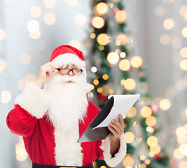 Image showing man in costume of santa claus with notepad