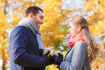 Image showing smiling couple with coffee cups in autumn park