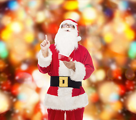 Image showing man in costume of santa claus with notepad