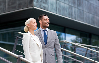 Image showing smiling businessmen standing over office building