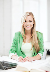 Image showing smiling student girl with laptop at school