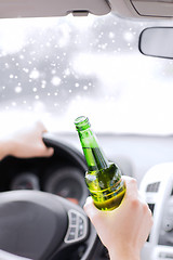 Image showing close up of man drinking alcohol while driving car