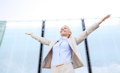 Image showing young smiling businesswoman over office building