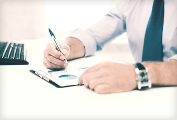 Image showing businessman working and signing papers