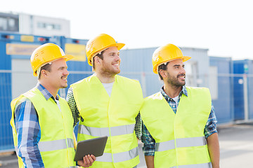 Image showing smiling builders in hardhats with tablet pc