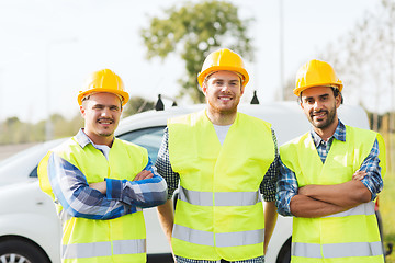 Image showing group of smiling builders in hardhats outdoors