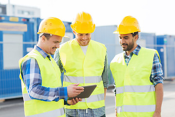 Image showing smiling builders in hardhats with tablet pc