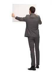 Image showing businessman or teacher with white board from back