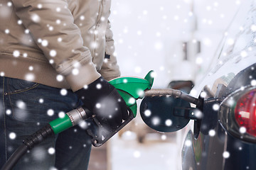 Image showing close up of man with fuel hose nozzle tanking car