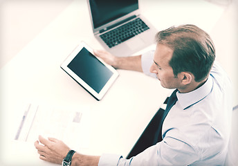 Image showing businessman with tablet pc and papers in office