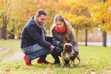 Image showing smiling couple with dog in autumn park