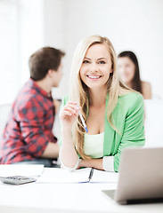 Image showing smiling student girl with laptop at school