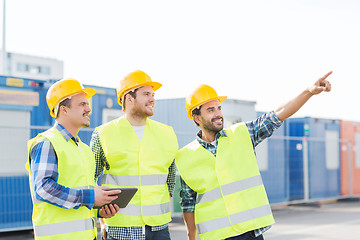 Image showing smiling builders in hardhats with tablet pc