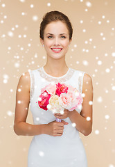 Image showing smiling woman in white dress with bunch of flowers