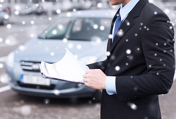 Image showing close up of man with clipboard and car documents